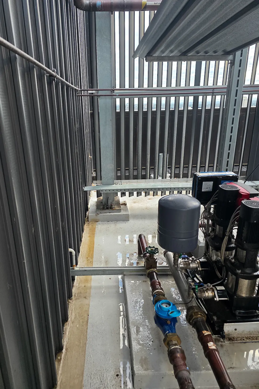 Booster pump set and pipework serviced in a screened rooftop plant area
