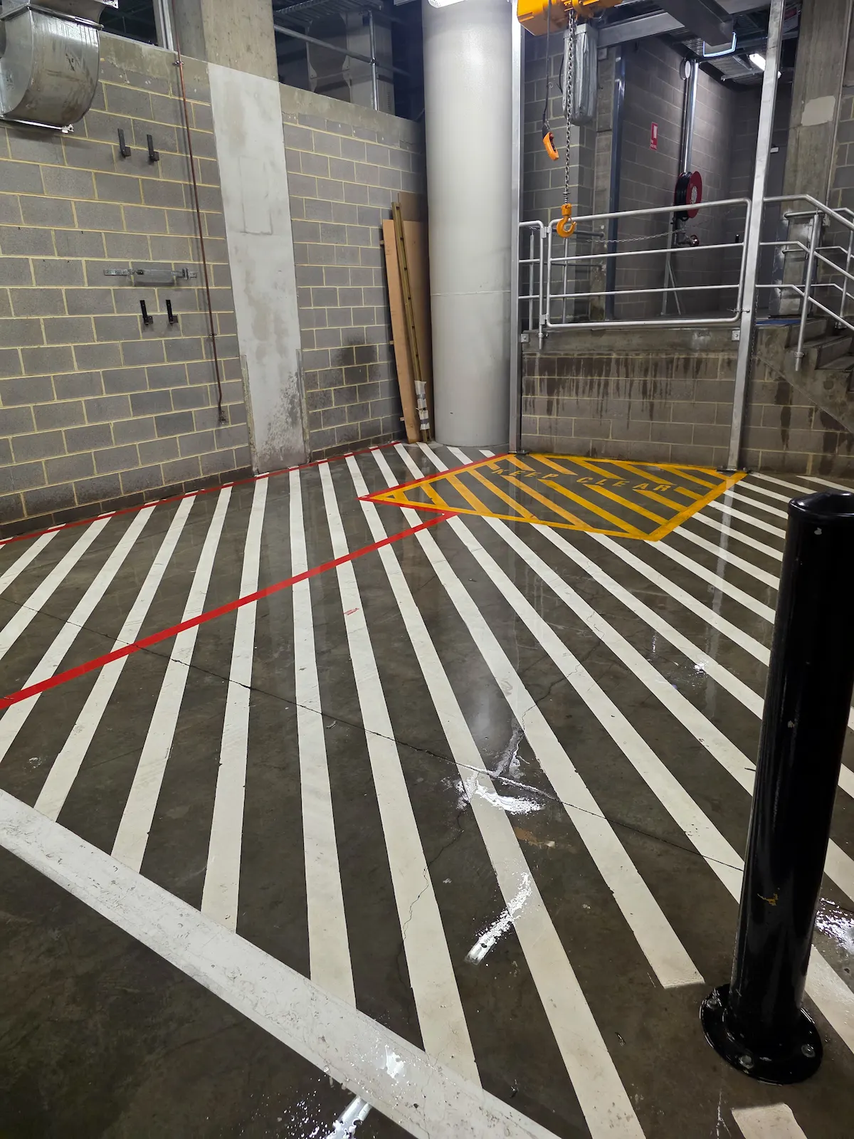 White hatched line marking and a yellow keep clear zone painted on a loading dock floor